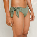 Side view of model in Sylvia bikini bottom, mineral green
