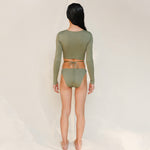 this picture is showcasing back view of the Doris long-sleeve swim crop top rashguard in mineral green paired paired with the Venus striped bikini bottom.it's a gender-neutral, nonbinary sustainable swimwear set with a clean, modern silhouette.