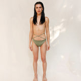 Model is wearing the Venus eco striped bikini bottom in mineral green which is a gender-neutral, nonbinary sustainable design shown from the front. it has a clean, minimal fit.