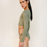 Side close-up of the Doris long-sleeve swim crop top rashguard in mineral green, a gender-neutral, nonbinary sustainable design with clean, minimal lines.