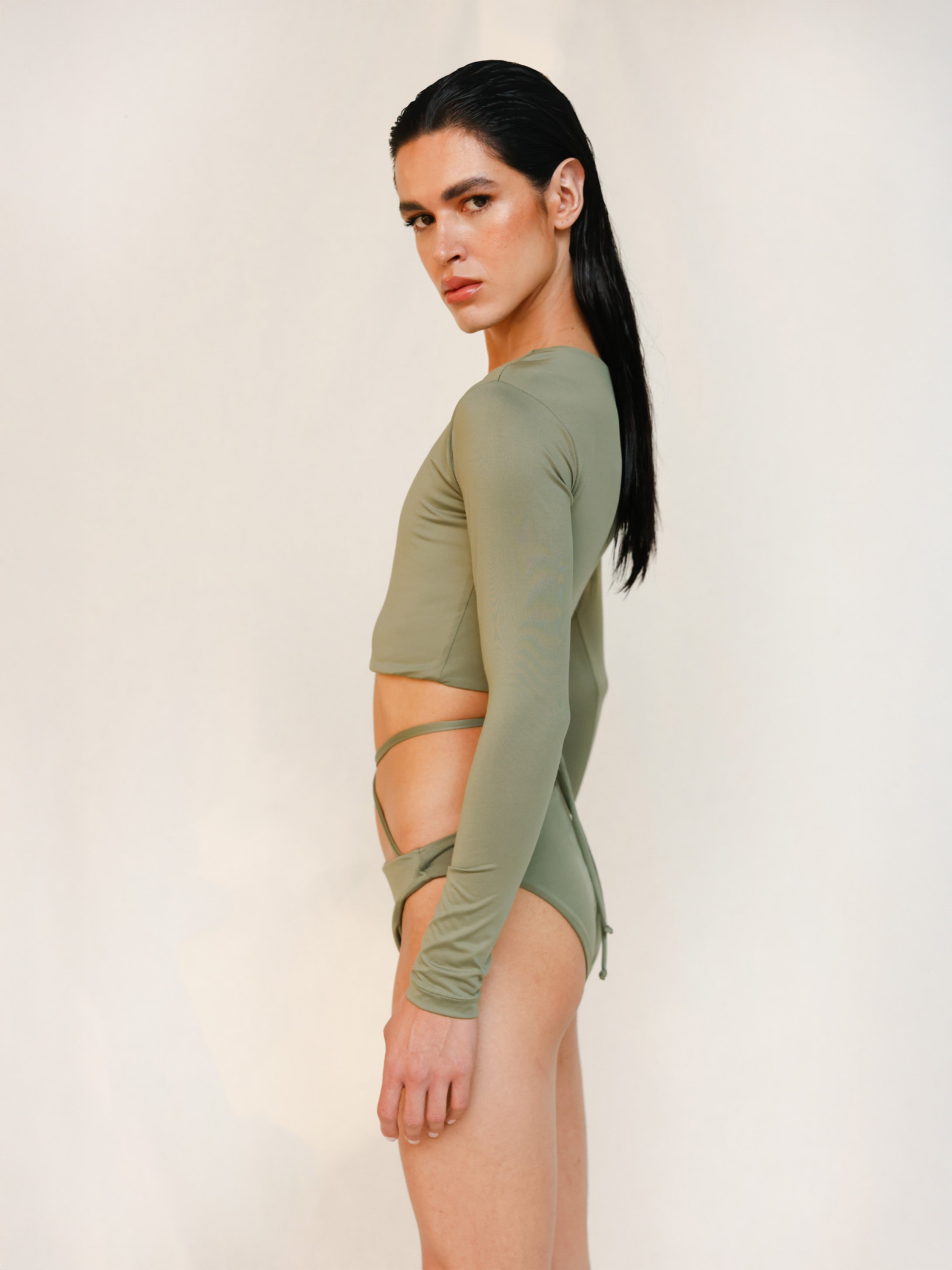 Side close-up of the Doris long-sleeve swim crop top rashguard in mineral green, a gender-neutral, nonbinary sustainable design with clean, minimal lines.