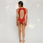 Person wearing Marsha one-piece swimsuit in terracotta red, back view