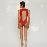 Person wearing Marsha one-piece swimsuit in terracotta red, back view
