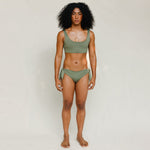 Front view of model wearing green swim top with scoop neck. 