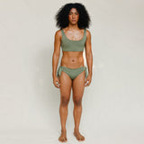 Front view of model wearing green swim top with scoop neck. 