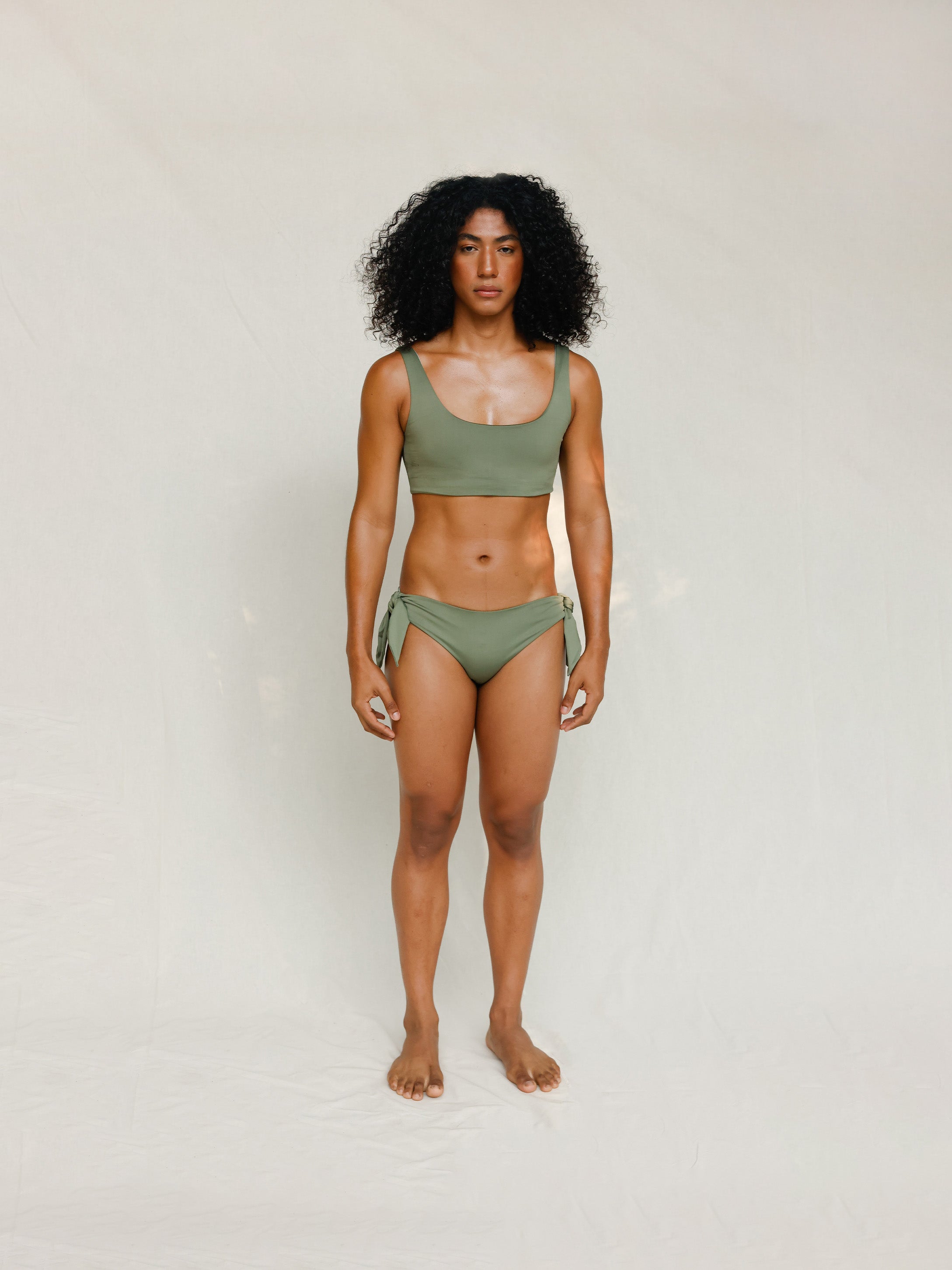 Front view of model wearing green swim top with scoop neck. 