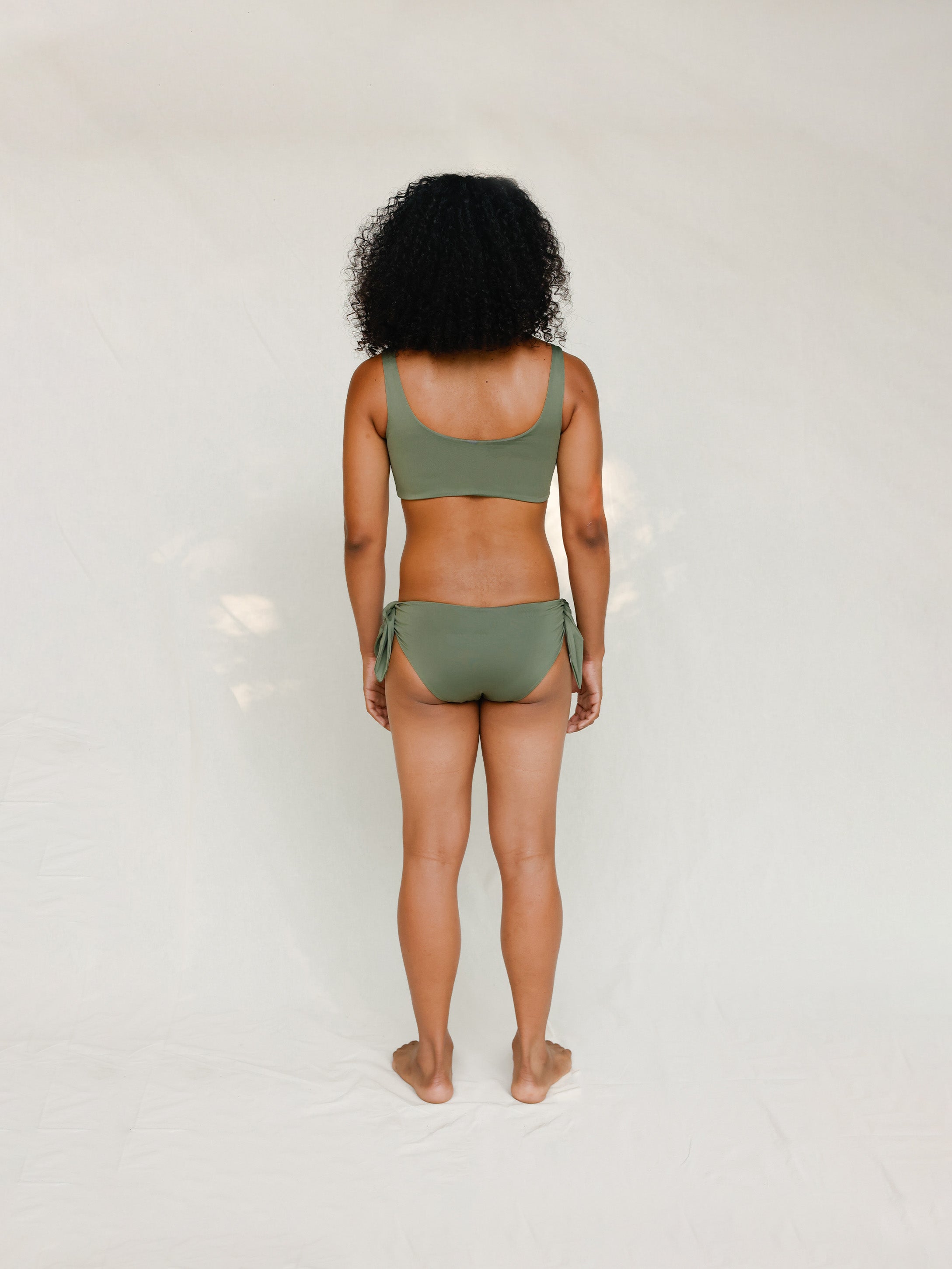 Back view of model in Audre top, mineral green