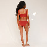 Back view of model in Audre top, terracotta red