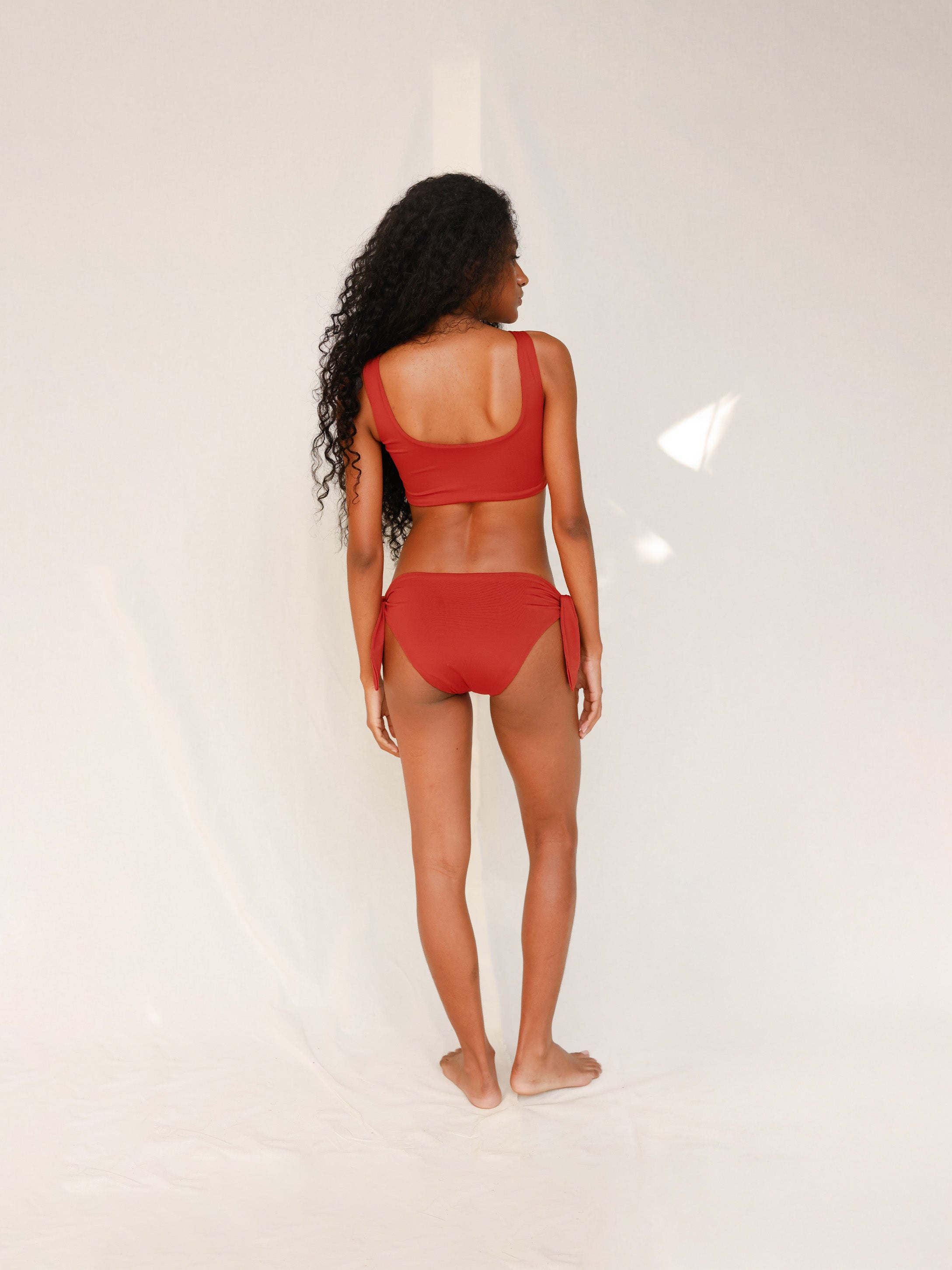 Back view of model in Audre top, terracotta red