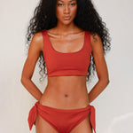 Front view of model wearing red swim top with scoop neck