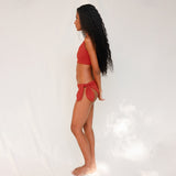 Side view of model in Audre top, terracotta red 