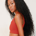 Side view of model in Audre top, terracotta red