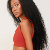 Side view of model in Audre top, terracotta red