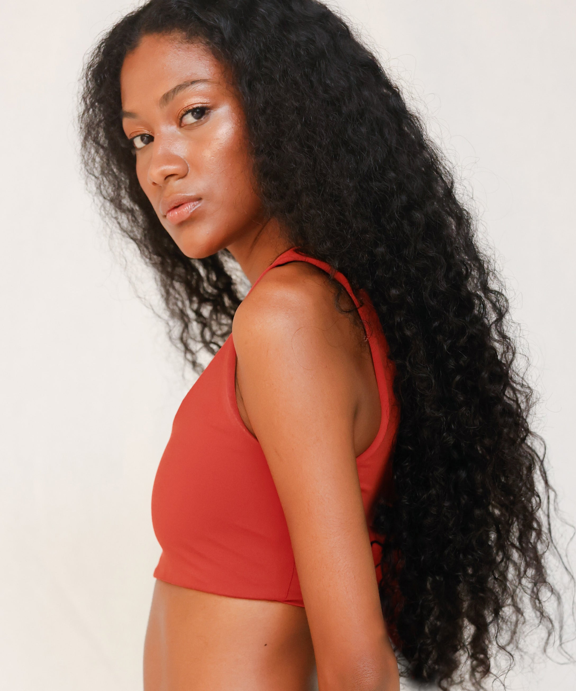Side view of model in Audre top, terracotta red