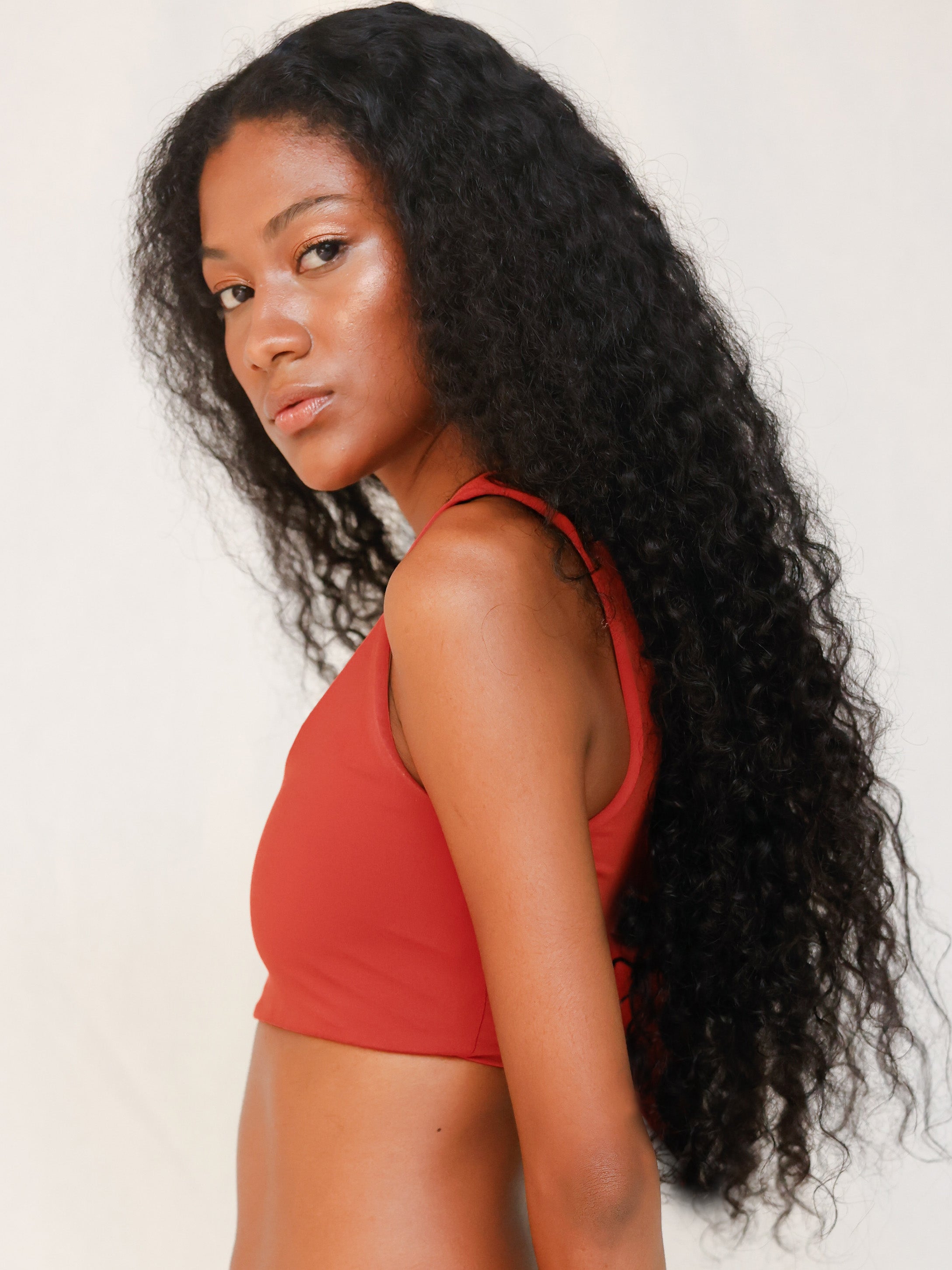 Side view of model in Audre top, terracotta red