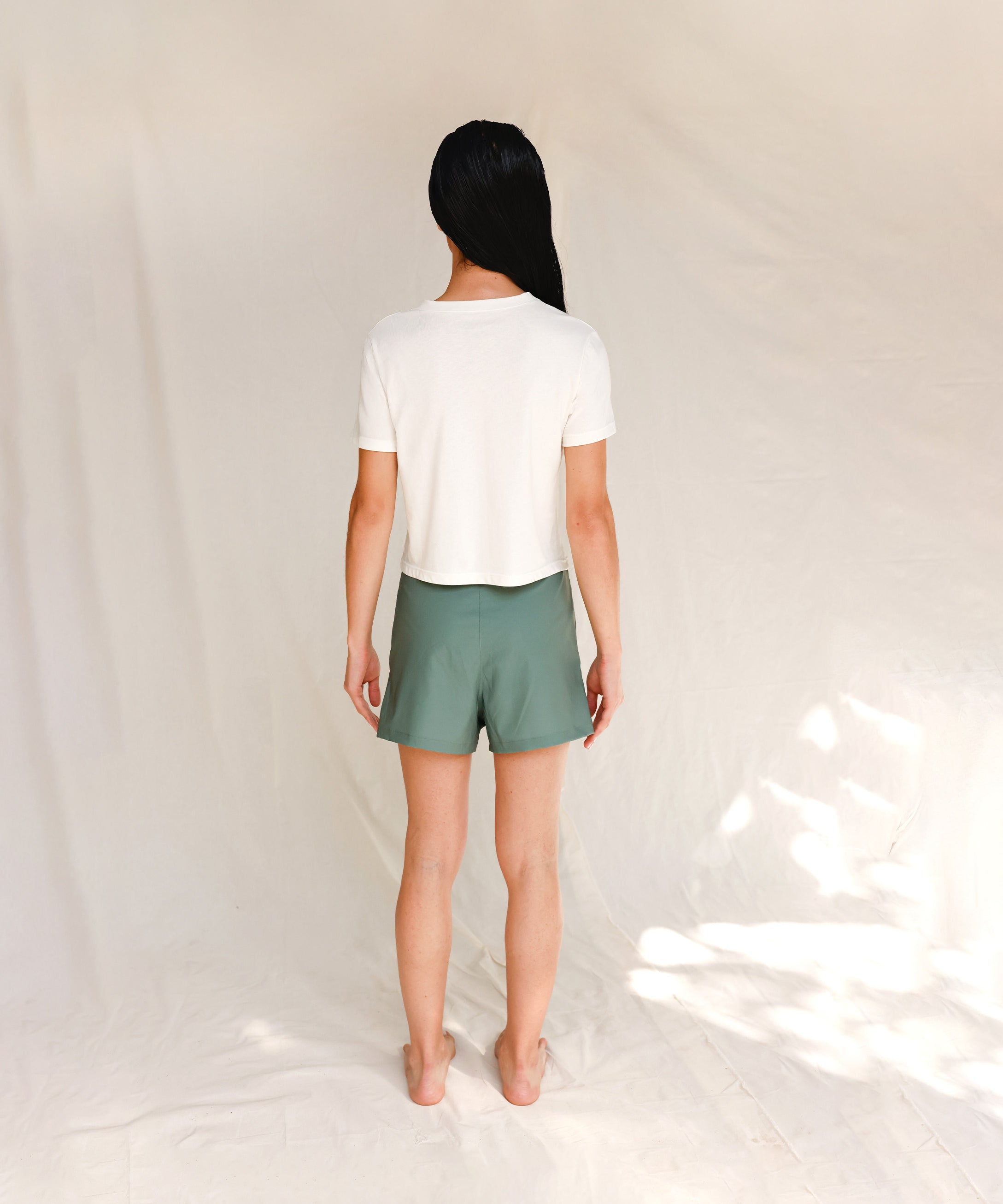 Back view of model in printed off-white cotton t-shirt 
