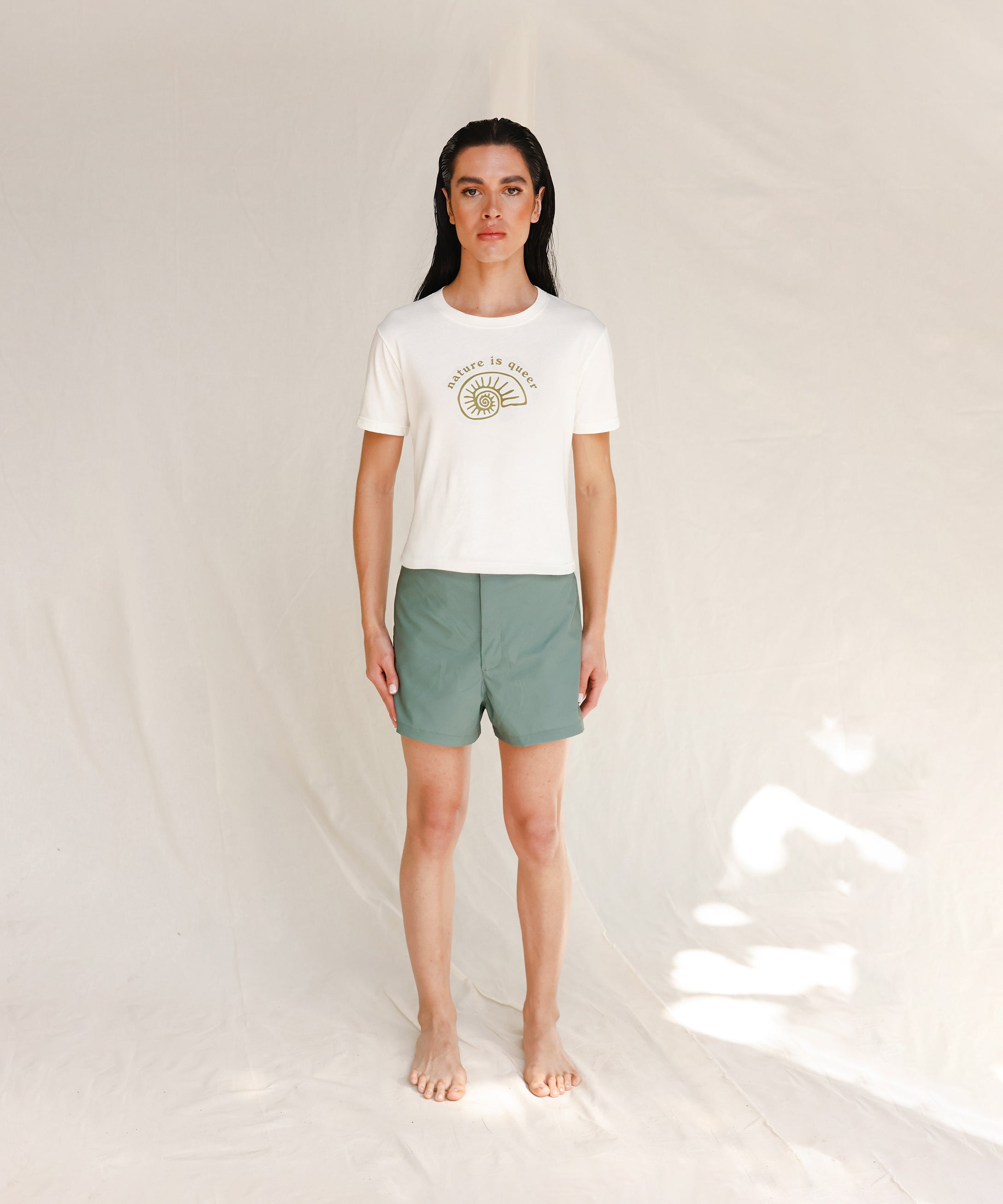Front view of model wearing white tee with Nature is Queer print