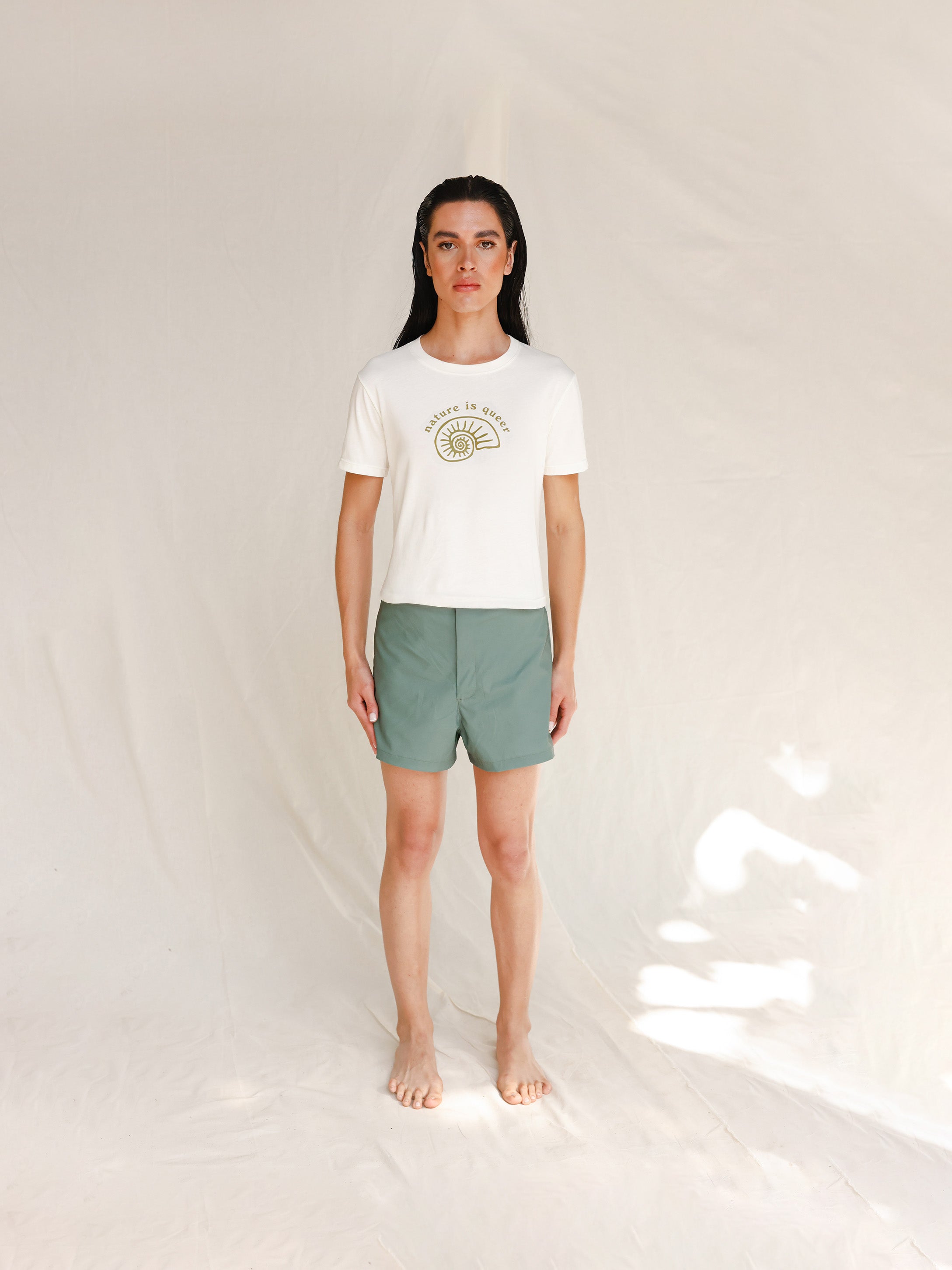 Front view of model wearing white tee with Nature is Queer print