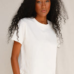 Front close-up view of model wearing plain off-white cotton t-shirt 