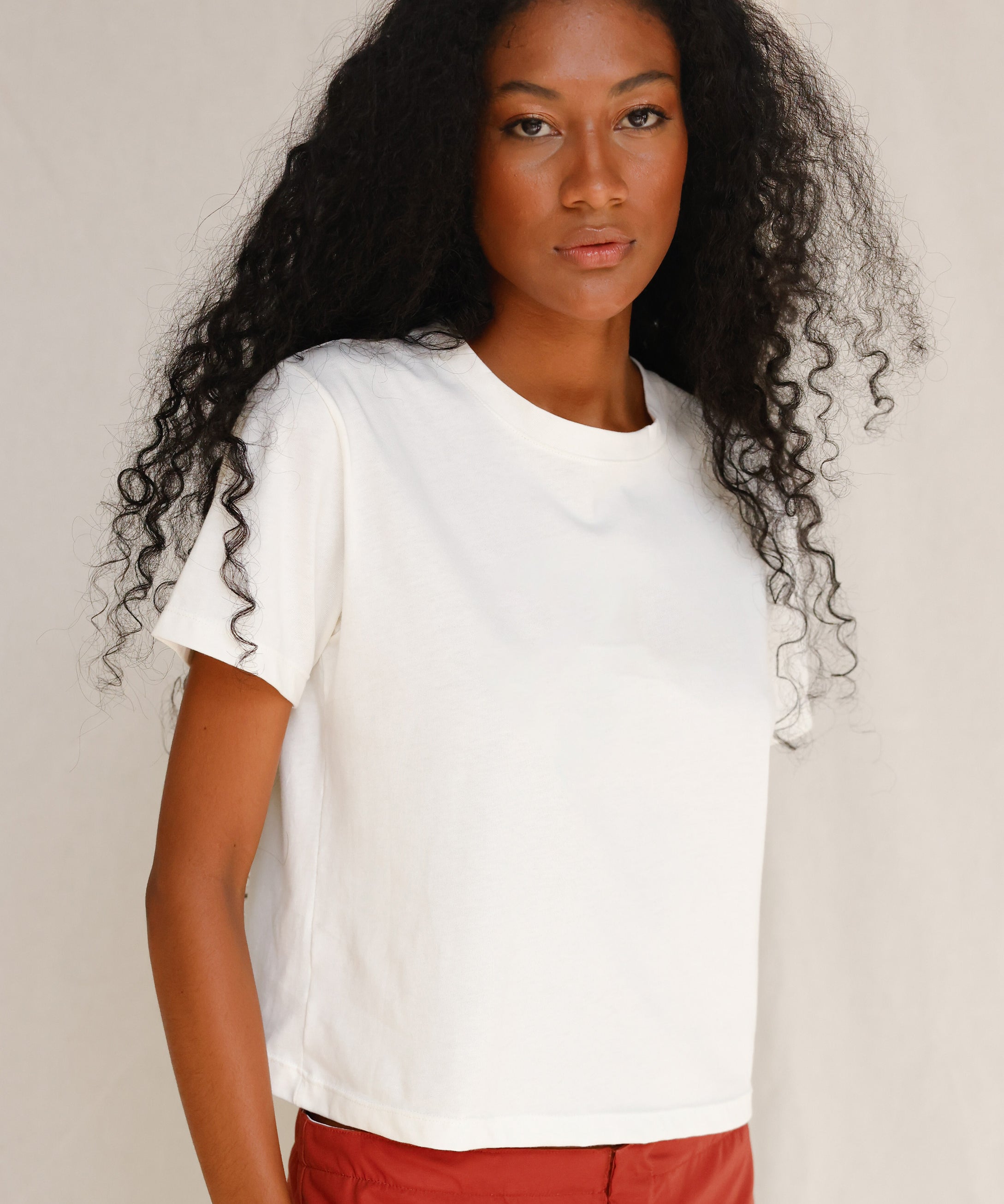 Front close-up view of model wearing plain off-white cotton t-shirt 
