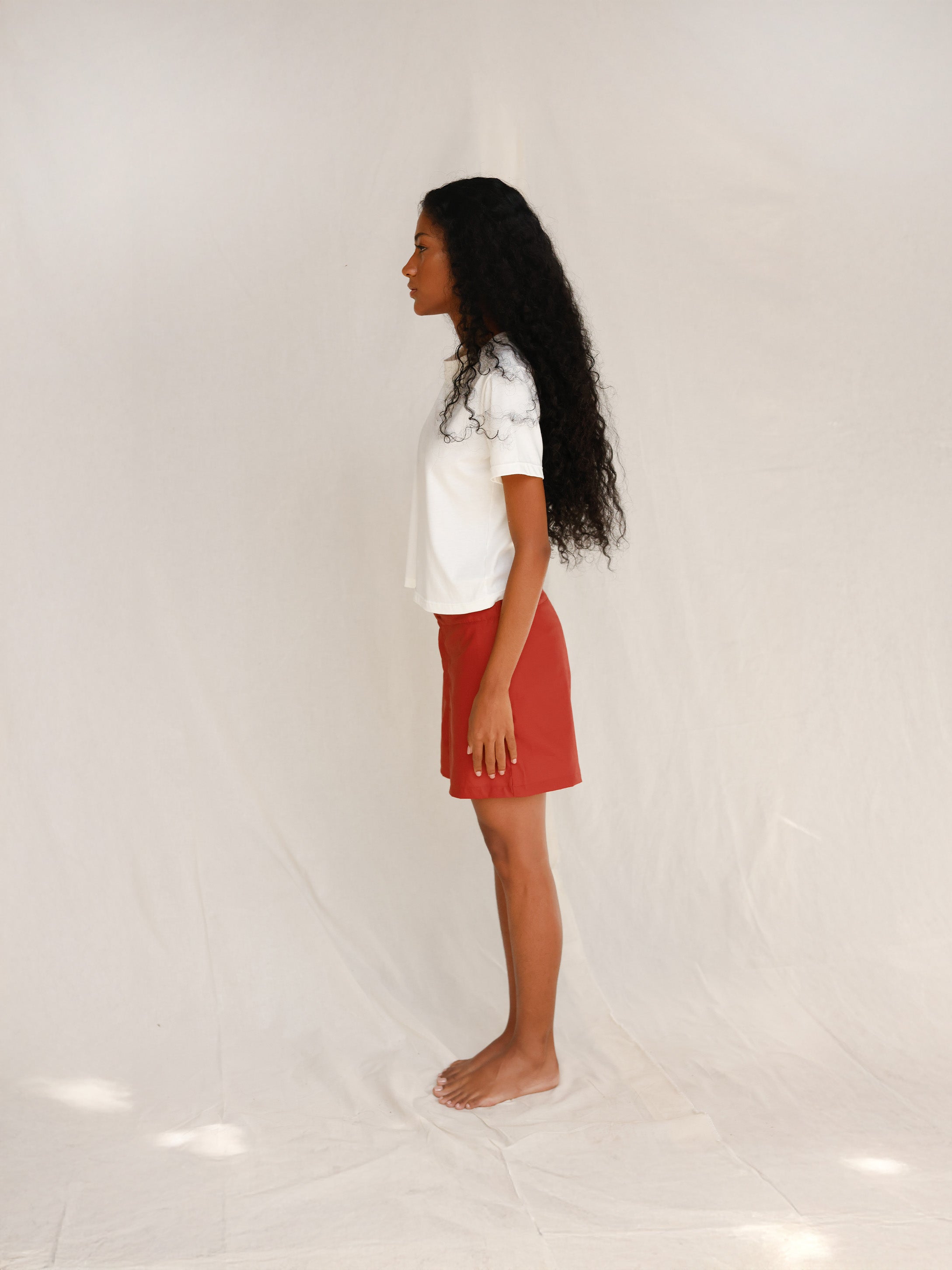 Side view of model in off-white tee 